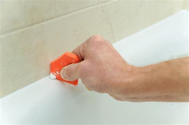 Should I caulk shower corners before grout?